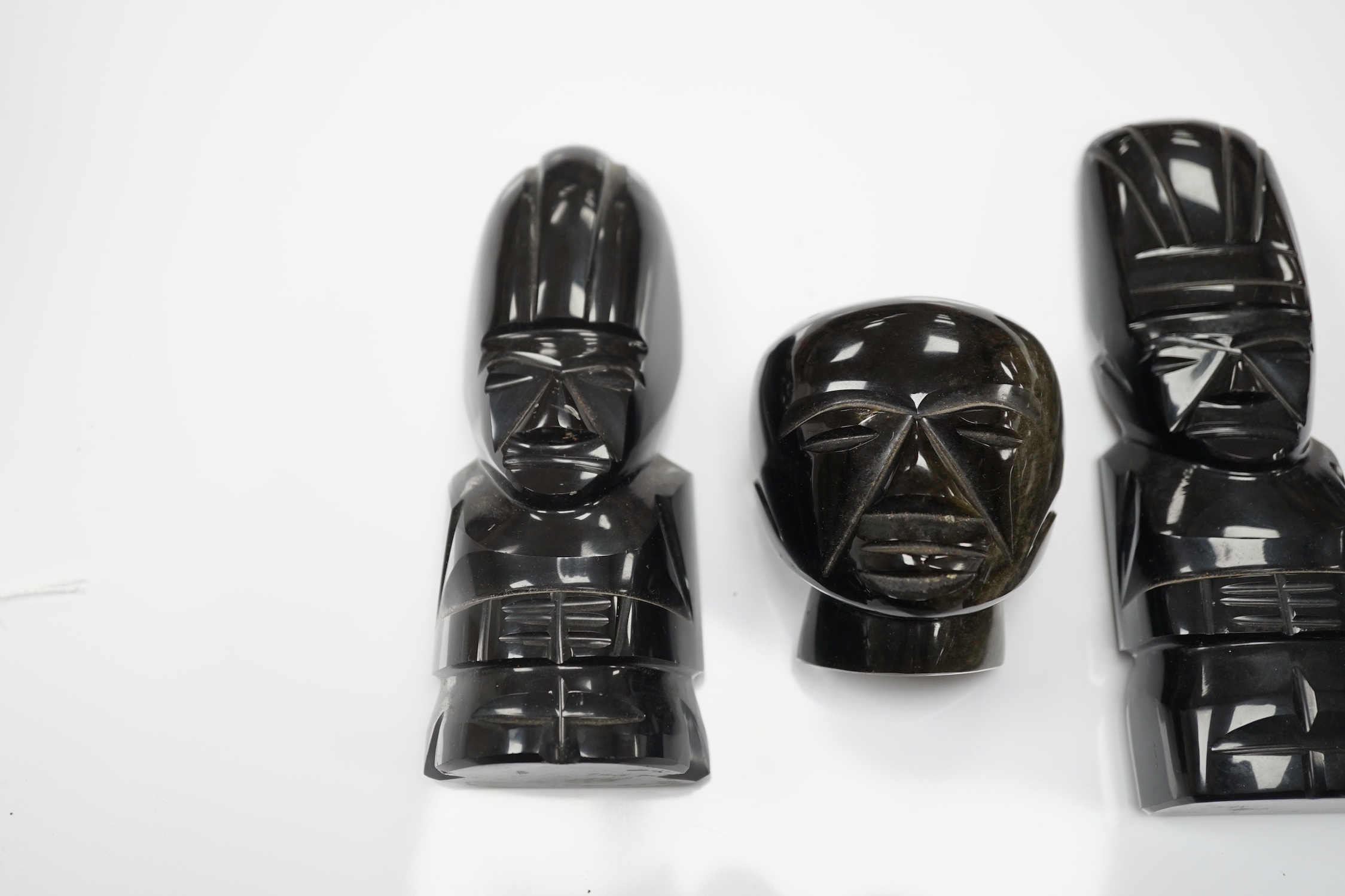 Three 20th century Aztec Mayan style carved obsidian stylised figures and a similar mask (4) tallest 15cm